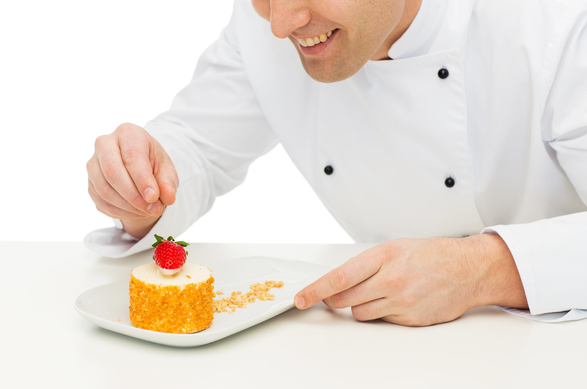 Student plating a dessert under instructor guidance